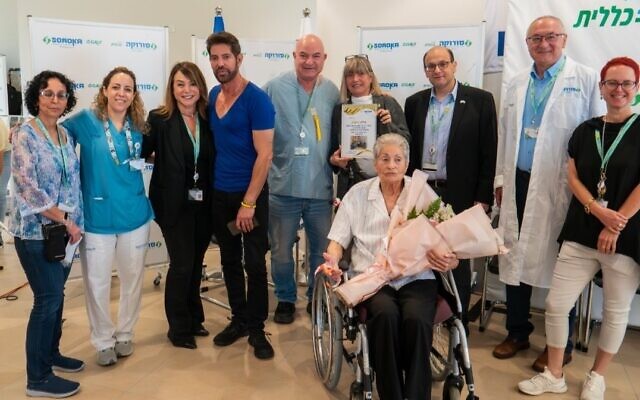 Elma Avraham sits in a wheelchair with Soroka Medical Center staff and her family ahead of her release from the hospital on May 8, 2024. (Soroka Medical Center)
