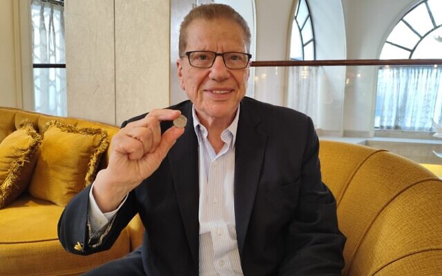 Philanthropist George S. Blumenthal with a Second Temple-era silver shekel coin, at the Waldorf-Astoria Hotel in Jerusalem, on May 20, 2024. (Gavriel Fiske/Times of Israel)