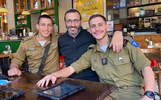 In this 2021 image, Rav Doron Perez (center) poses with his two soldier sons Yonatan (left, then 22) and Daniel (then 20), who was slain on October 7, 2023, and his remains captured by Hamas and taken to Gaza. (courtesy)