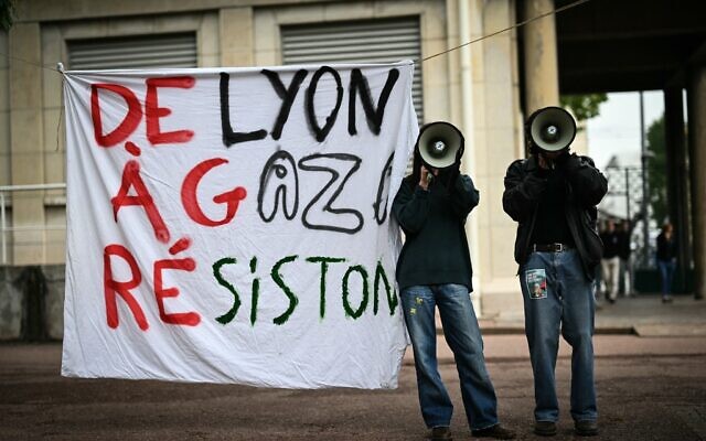 Demonstrators use megaphones next to a banner reading in French "From Lyon to Gaza, lets resist!" during aprotest action in the courtyard of the Institute of Political Studies (Sciences Po) building in Lyon, central Eastern France, on April 30, 2024. (Photo by OLIVIER CHASSIGNOLE / AFP)
