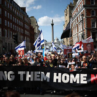 Protesters holding placards and waving Israeli flags take part in a march in central London, on June 2, 2024, to bring attention to the plight of the hostages still held in Gaza. (HENRY NICHOLLS / AFP)