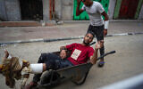 An injured Palestinian man is wheeled away from a UN school housing displaced Palestinians that was hit by an Israeli strike in Nuseirat, in the central Gaza Strip, on June 6, 2024. The Hamas-run Gaza health ministry claimed there were dozens of civilian fatalities. The IDF said it hit three classrooms where Hamas and Islamic Jihad terrorists were gathered, killing many of them. (Bashar TALEB / AFP)