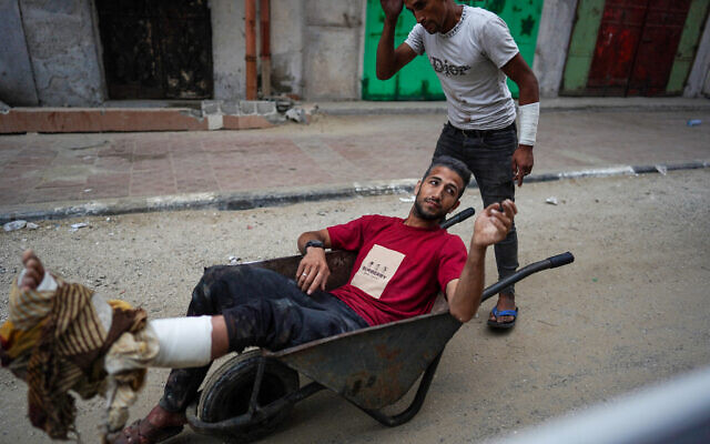 An injured Palestinian man is wheeled away from a UN school housing displaced Palestinians that was hit by an Israeli strike in Nuseirat, in the central Gaza Strip, on June 6, 2024. The Hamas-run Gaza health ministry claimed there were dozens of civilian fatalities. The IDF said it hit three classrooms where Hamas and Islamic Jihad terrorists were gathered, killing many of them. (Bashar TALEB / AFP)