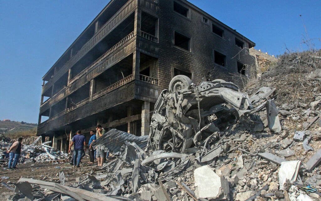 People inspect the destruction outside a charred building hit by an Israeli airstrike in the southern Lebanese town of Wadi Jilo, east of Tyre, on June 6, 2024 (Mahmoud AL-ZAYYAT / AFP)