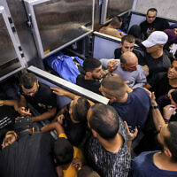 Mourners gather in a morgue containing the bodies of three Palestinian men killed during an Israeli army raid in Jenin in the West Bank on June 6, 2024. (Jaafar Ashtiyeh/AFP)