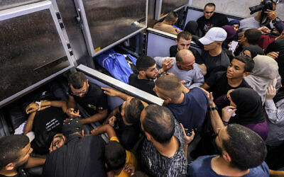 Mourners gather in a morgue containing the bodies of three Palestinian men killed during an Israeli army raid in Jenin in the West Bank on June 6, 2024. (Jaafar Ashtiyeh/AFP)