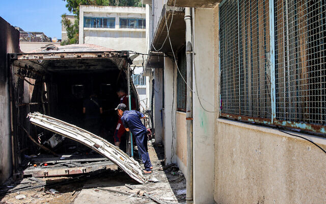Youths inspect damage to a storage container that was hit by an Israeli strike at the Asmaa school run by the UN Relief and Works Agency for Palestine Refugees (UNRWA), in the Shati camp west of Gaza City on June 7, 2024. The IDF says a Hamas cell was operating from the container (Omar AL-QATTAA / AFP)