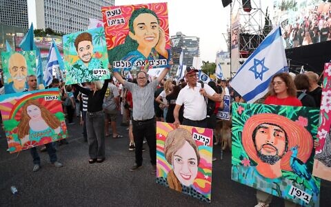 An image depicting Noa Argamani (C), one of four Israeli hostages rescued by the Israeli army, is held up as activists rally during an anti-government demonstration, calling for the return of hostages being held in the Gaza Strip, Tel Aviv, June 8 2024. (Jack Guez/AFP)