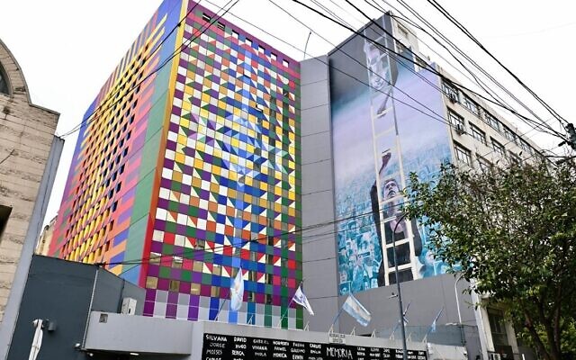 The colorful new facade of Buenos Aires' AMIA Jewish center abuts a mural painted to memorialize the 1994 bombing that killed 85 people there. (Juan Melamed/JTA)