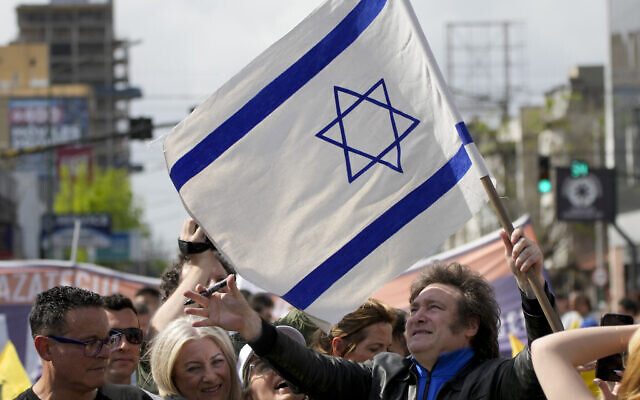 Then-presidential hopeful Javier Milei holds an Israeli flag during his campaign rally in Lomas de Zamora, Argentina, October 16, 2023. (Natacha Pisarenko/AP)