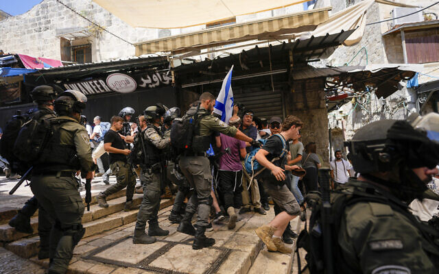 Police officers separate Israelis and Palestinians in a street in the Muslim Quarter of Jerusalem's Old City, shortly before a march through the area by Jewish nationalists on Jerusalem Day, which marks the unification of east and west of the city in the 1967 Six Days War, June 5, 2024. (Ohad Zwigenberg/AP)
