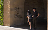 Students walk by graffiti saying 'Death to Israel' near the office of the President at Stanford University in Palo Alto, California, June 5, 2024. (AP Photo/Nic Coury)