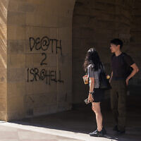 Students walk by graffiti saying 'Death to Israel' near the office of the President at Stanford University in Palo Alto, California, June 5, 2024. (AP Photo/Nic Coury)