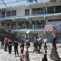 Palestinians look at the aftermath of an Israeli strike on a UN-run school in the Nusseirat refugee camp in the Gaza Strip, June 6, 2024, that the IDF says targeted more than 20 terror operatives working there. (AP Photo/Jehad Alshrafi)