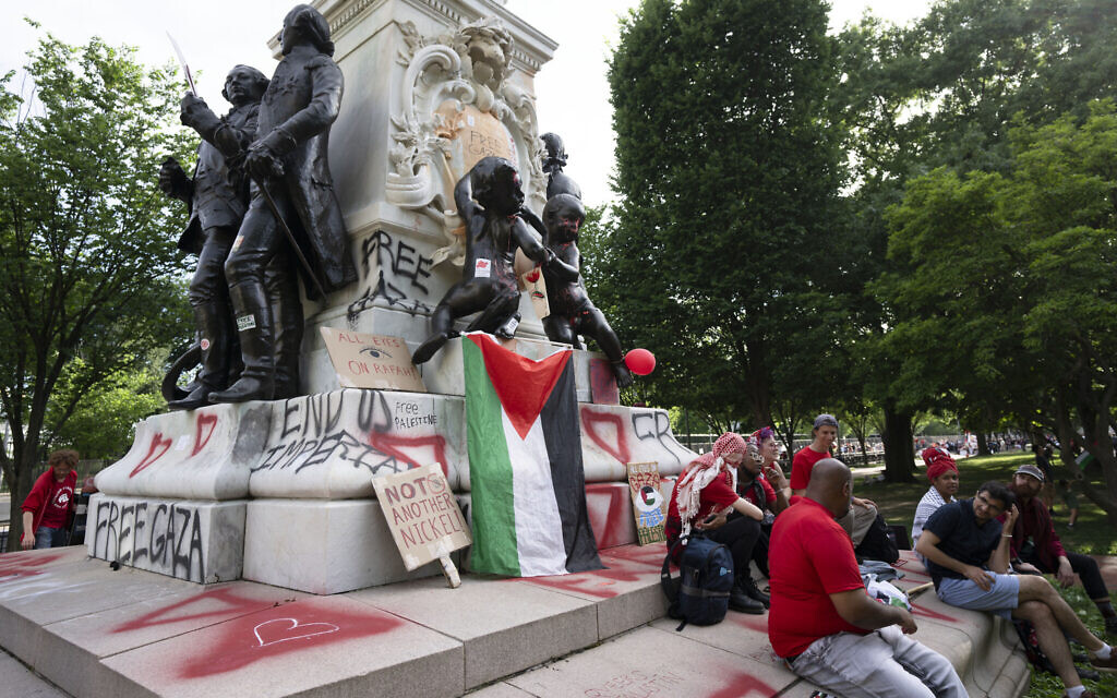 A group of protesters rest at the foot of the vandalized statue of French General Marquis de Lafayette at the end of an anti-Israel, pro-Palestinian in front of the White House in Washington, June 8, 2024. (AP Photo/Manuel Balce Ceneta)