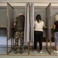 Voters fill in their ballot papers at a polling station during the European Parliament and the local elections in Salgotarjan, Hungary, June 9, 2024. (Peter Komka/MTI via AP)