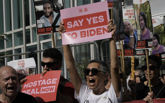 Families and supporters of Israeli hostages held by Hamas in Gaza hold banners and flags during a protest calling for their return, outside meetings of US Secretary of State Antony Blinken in Tel Aviv, Israel, Tuesday, June 11, 2024. (AP Photo/Leo Correa)