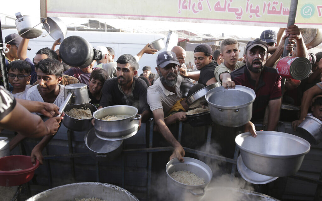 Men collect food aid ahead of the upcoming Eid al-Adha holiday in Khan Younis, Gaza Strip, June 15, 2024. (AP Photo/Jehad Alshrafi)