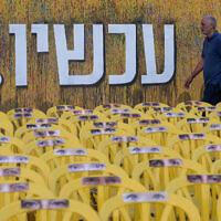 People walk past a large mural reading "Now" at  Hostage Square in Tel Aviv. June 2, 2024. (Avshalom Sassoni/Flash90)