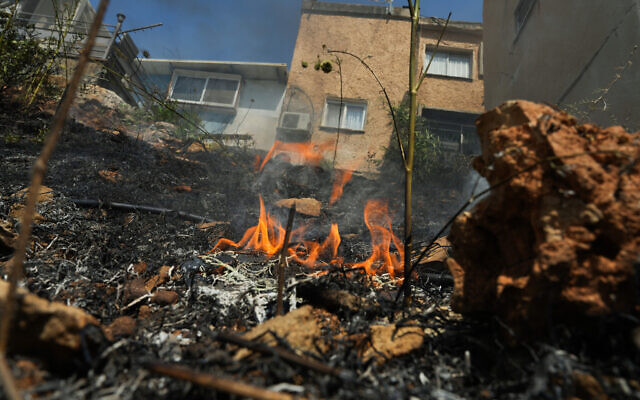 The remains of a large fire caused from rockets fired from Lebanon burns near a home in the northern Israeli town of Kiryat Shmona, June 4, 2024. (Ayal Margolin/Flash90)