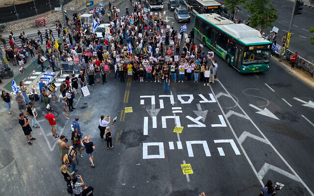 Demonstrators call for the release of Israeli hostages held in the Gaza Strip outside the Hakirya Base in Tel Aviv, June 4, 2024. The tape on the road reads "Deal = victory of life" (Avshalom Sassoni/Flash90)