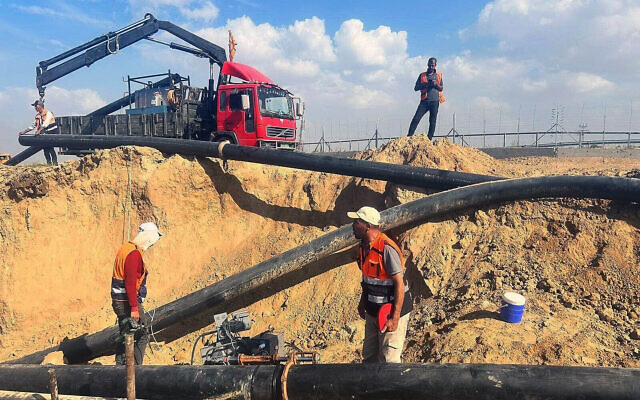 This undated photo shows Palestinian Water Authority workers repairing the Gazan side of a pipeline leading water from Israel during the country's war with Hamas. (Courtesy)