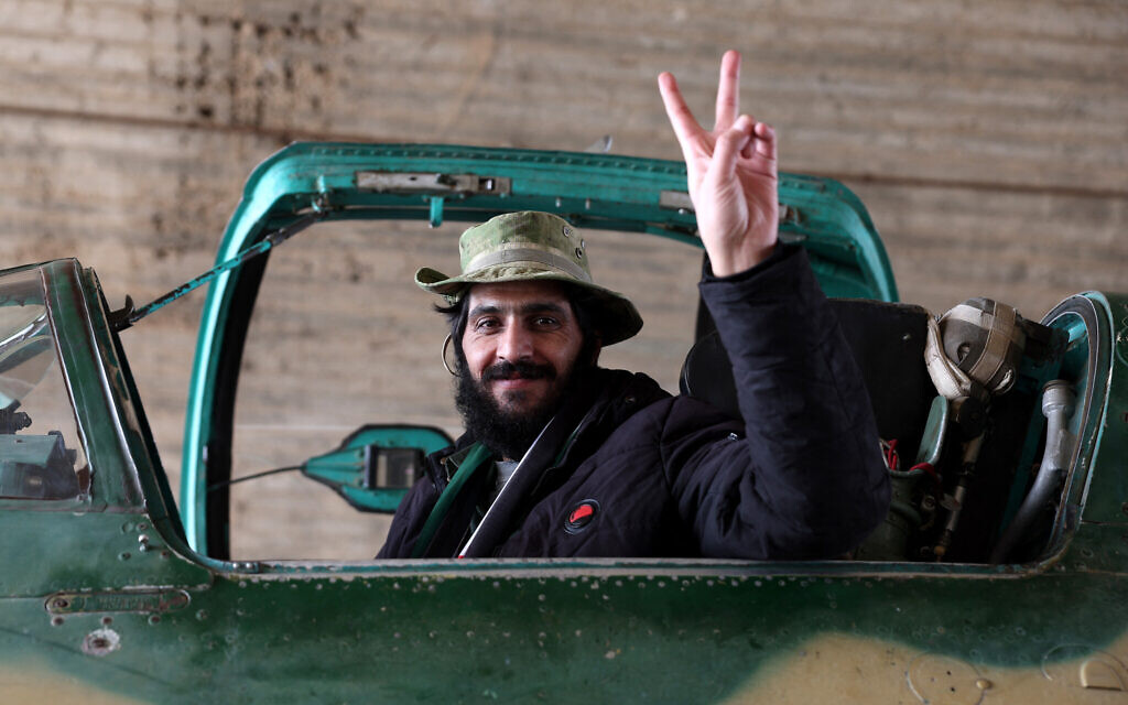 An anti-government fighter gestures as he poses for a picture in the cockpit of a Syrian army jet after rebels took over a military airbase near the central city of Hama, on December 6, 2024. (OMAR HAJ KADOUR / AFP)